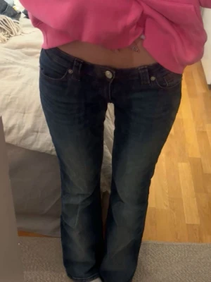 Mörkblå flare jeans - Säljer ett par mörkblå flare jeans med klassisk femficksdesign och låg midja. Jeansen har snygga super snygga mörkröda sömmar och coola bakfickor. Passar perfekt på mig som är 17 år med storlek 34/36 och 168cm lång. Skriv ifall eventuella frågor!❤️
