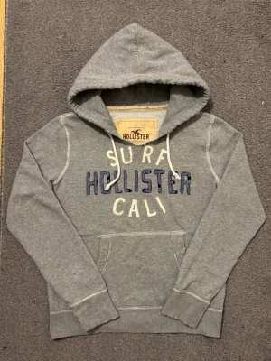 Vintage Hollister Hoodie - Extremt sällsynt och unik Hollister Hoodie med tryck | Hoodien har en unik sliten & distressed design! | Mycket bra skick| Storlek M | Längd≈ 68 cm, Bredd 58 cm under armhål-armhåla| Modell 175cm, 68kg | Priset ej hugget i sten! 