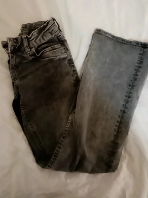 Grå jeans från Gina Tricot - Snygga grå jeans från Gina Tricot i tvättad look. Klassisk femficksmodell med raka ben och normal midja. Jeansen är tillverkade i ett mjukt denimtyg som passar perfekt till vardagsstilen. Stängs med dragkedja och knapp.