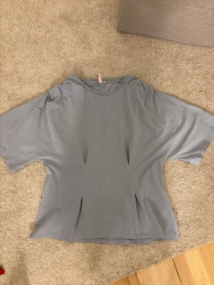 Ljusblå T-shirt från Nelly - Säljer en ljusblå tröja från Nelly med sömmar både fram, bak och på axlarna. Aldrig använd därav inga defekter. Storlek XL