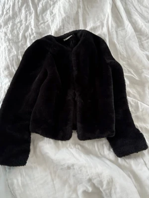 Svart gosig vårjacka - Mysig svart jacka från H&M med klassisk rak passform och rund halsringning. Jackan har långa ärmar och stängs framtill. Perfekt för dig som vill ha en stilren och trendig look med extra fluffig känsla.💓✨