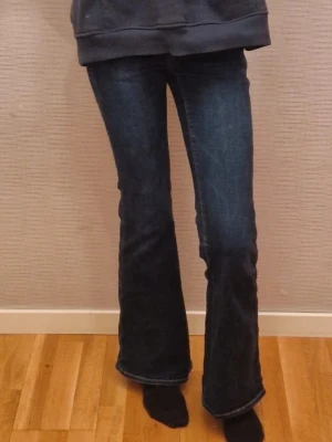 American eagle jeans - Jätte snygga mörkblåa flared/bootcut jeans från American Eagle. Dem är i stretchigt material. Det står storlek 000 (eftersom de är köpt i Canada) men jag bär XXS/32 och de passar bra. Jag säljer eftersom de inte kommer till använding. Det står super high waist men dem sitter bara precis vid/under naveln för mig, skulle säga att dem är vanlig high rise. Dem är använda men det märks inte, dem ser typ helt nya ut!Priset kan diskuteras!☺️🌸
