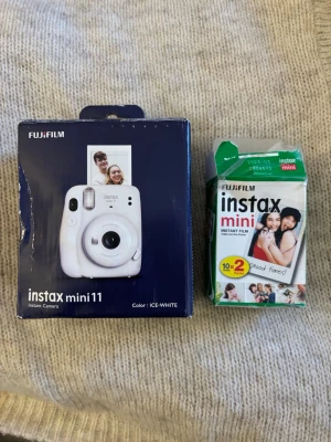 Fujifilm Instax Mini 11 Ice White kamera - Säljer en Fujifilm Instax Mini 11 instantkamera i färgen Ice White. Kameran har rund form och är tillverkad i plast. Medföljer även Instax Mini film för 10 bilder. Perfekt för att ta direktbilder och selfies med automatisk exponering. Allt är i super bra skick och knappt använd. Själva förpackningen är lite skadad dock🥰
