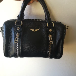 Zadig & Voltaire handväska - mått: 24x14.5x11.6cm , mycket fint begagnat skick. obs! se mindre deformation på alla fyra handtagen på samma ställe, annars är i mycket fint skick, axelrem är 110 cm lång