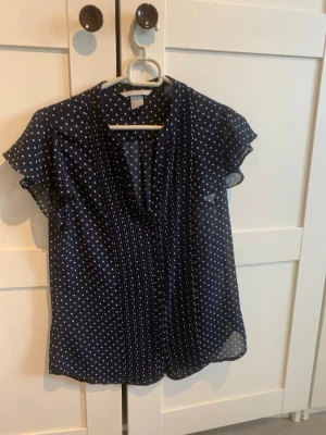 Mörkblå prickig blus  - Snygg mörkblå blus med vita prickar.