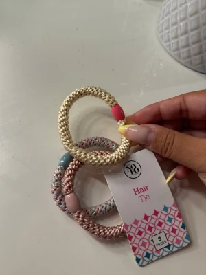 Färgglada hårsnoddar  - Säljer ett 3-pack tjocka hårsnoddar från No 70 i beige, rosa och mixade pastellfärger. Varje snodd har en dekorativ pärldetalj i olika färger som ger en söt touch. Perfekta för att piffa upp din frisyr och hålla håret på plats.