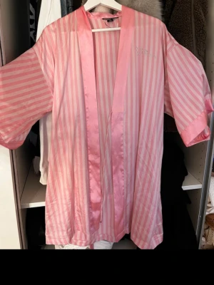 Rosa randig morgonrock satin Victoria secret - Snygg rosa morgonrock i satin med vita och ljusrosa ränder. Från Victoria secret köpte den för 1000 kr men säljer för 500