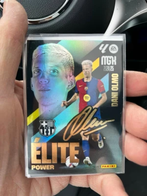 Panini Elite Power fotbollskort Dani Olmo - Säljer ett Panini Elite Power samlarkort med Dani Olmo i Barcelona-tröja. Kortet har holografisk yta, guldtext och autograftryck. Perfekt för dig som gillar fotboll och samlarkort. Kortet är skyddat i plastficka.