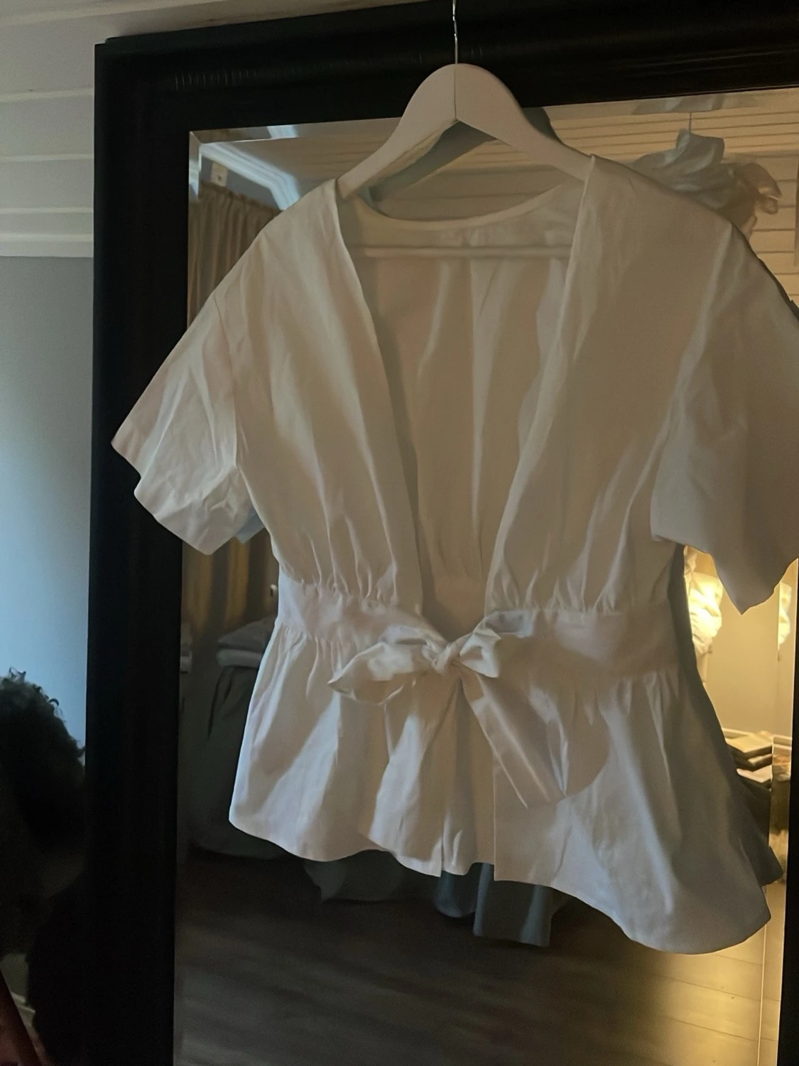 Vit blus med rosett på ryggen
