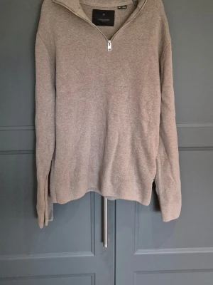  Beige stickad tröja med dragkedja, premium. - Stickad tröja från Jack & Jones i beige färg. Tröjan har halv dragkedja framtill, hög krage och är tillverkad i mjukt material. Perfekt för lager på lager och enkel att matcha med olika outfits. Nypris 600:-