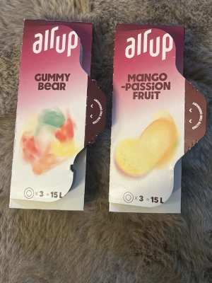 Air Up smaksatta pods 2-pack - Säljer två förpackningar Air Up smaksatta pods i smakerna Gummy Bear och Mango Passion Fruit. Varje förpackning innehåller 3 pods som räcker till cirka 15 liter vatten. Pods är färgglada och kommer i originalkartong.