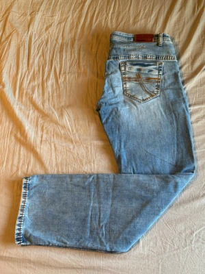 Jeans Camp David - Ljusblå jeans från Camp David med raka/avslappnade ben. Storlek: W38 L36. Måtten är: Midja - 50 cm  Längd - 120 cm Innerbenslängd - 91 cm  Fotöppning - 21 cm  Lår - 34 cm