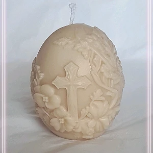 Dekorativt äggformat ljus med kors - Unikt äggformat ljus i beige färg med detaljerade blommor och ett kors i relief. Perfekt som dekoration eller present till någon som gillar religiösa motiv och handgjorda detaljer.