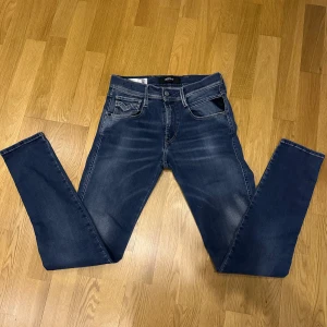 Replay Hyperflex Anbass jeans - Säljer ett par Replay Hyperflex Anbass jeans i blå färg. Byxorna är väldigt, snygga och läderpatch bak i midjan. Modellen är slim fit med stretchigt material.