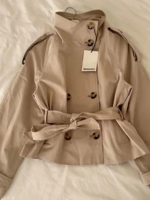 Berskha trenchcoat  - Slutsålda Berskha trenchcoat, aldrig använt, lappen sitter kvar och jag skickar den i original paketet den kom i. Pris kan alltid diskuteras💗