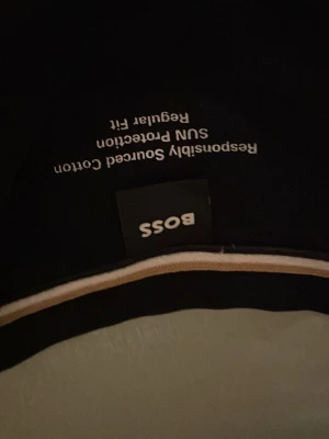 Svart BOSS t-shirt med logga - Snygg svart t-shirt från BOSS med stor vit logga på bröstet. Tillverkad i bomull med regular fit och klassisk rund hals. Perfekt för dig som gillar stilrena och tidlösa plagg med tydlig branding.