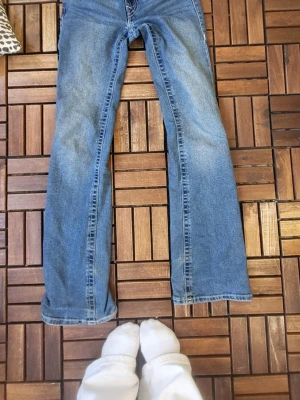 Blå bootcut jeans från true religion  - Säljer ett par true religion jeans. Säljer de pga av att jag inte gillar hur de sitter på mig. De är mid waist och är använda ett fåtal gånger och är i jätte bra skick! Köpta för 1800 så säljer de för 500 men pris kan diskuteras. Storlek 24 i midjan och är lite långa i benen på mig som är 167. 