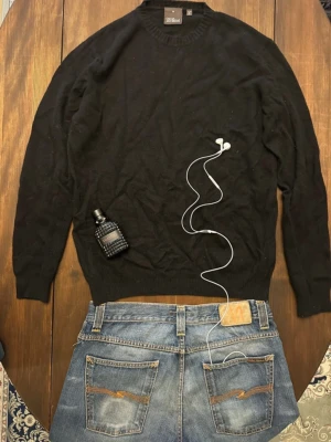 Svart stickad tröja Oscar Jacobson - Klassisk svart stickad tröja från Oscar Jacobson i storlek M. Tröjan har rund halsringning och ribbade muddar vid ärmslut och nederkant. Perfekt basplagg i mjukt material som passar till det mesta.