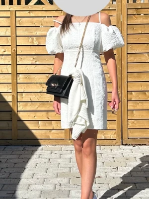 Vit kort offshoulder klänning - Vit klänning med puffiga offshoulder-ärmar och smala axelband. Klänningen är perfekt för sommaren och studenten.