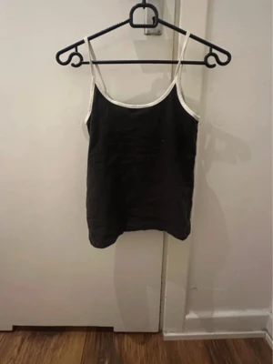 Mörkgrå linnetopp med vita band - Basic top från HM. Har klippt av tagen pgr av kliande men vet att jag köpte den på HM för nått år sen. Passar XS-S Använt ett par gånger men i perfekt skick (säljer även på vinted)