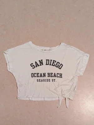 Mag tröja  - Cropped vitt top. Använd 1-3 gånger. En liten fläck finns på baksidan av tröjan. Fläcken visas på bild