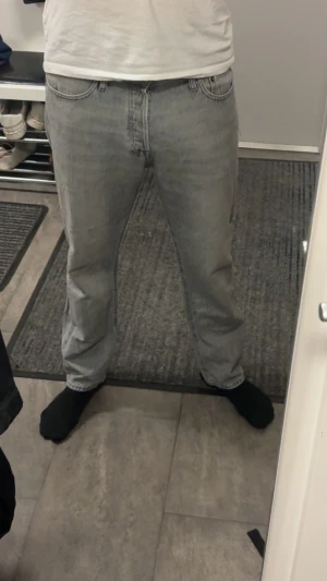 Grå relaxed jeans från Jack & Jones - Säljer ett par gråa jeans från Jack & Jones, modell Relaxed/Chris. De har en avslappnad passform med raka ben och klassisk femficksdesign. Jeansen är tillverkade i denim och har en snygg ljusgrå tvätt som ger en cool vibe.