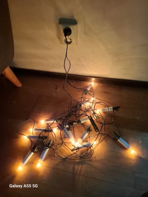 Elektrisk ljusslinga med vita ljus - Elektrisk ljusslinga med flera vita plastljus och gröna klämmor för enkel upphängning. Slingan har svart sladd och kopplas in med vanlig stickkontakt. Perfekt för att skapa mysig stämning i hemmet, särskilt under vintern.