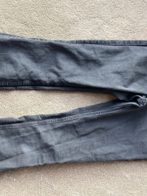 Snygga svarta bootcut jeans - Ett par svarta jeans med bootcut passform och klassiska bakfickor. Jeansen har en lätt utsvängd benslut och är tillverkade i ett mjukt denimtyg. Perfekta för dig som gillar en retroinspirerad stil.