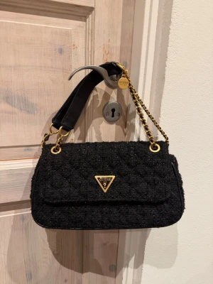 Guess väska  - Svart guess väska med reglerbara band, sparsamt använd 