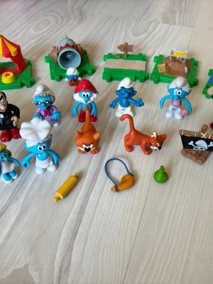 Smurfar lekset från Peyo 2009-2013 plastfigurer - Säljer en samling Smurfar-figurer i plast med olika tillbehör som cykel, katter, skyltar och små leksaksprylar. Perfekt för dig som gillar samlarprylar eller vill ha nostalgiska leksaker.                                                                   11 smurfar + 8 tillbehör 
