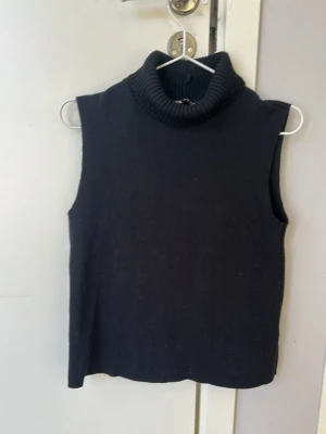 Svart ärmlös polotröja från Zara - Säljer en snygg svart stickad ärmlös polotröja från Zara💕💕Tröjan har en hög, ribbad polokrage och är gjord i ett mjukt material💕💕I mycket bra skick💕💕Jag säljer den för 60 kr💕💕Hör av er vid intresse💕💕