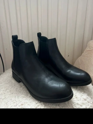Svarta boots  - Säljer dessa vackra svarta skor i storlek 39. Köpta på din sko för ett år sedan och endast använda 1 gång på begravning🤍Säljer för 250kr och nypris är 399kr💗Se bild 1&2 för lite slitage det har tyvärr mina katter orsakat när dem legat i garderoben☺️Men det syns knappast 