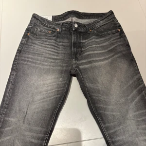 Grå tvättade jeans med raka ben - Säljer ett par grå jeans med snygg tvättad effekt och raka ben. Klassisk femficksmodell. Jeansen har en modern look och passar perfekt till en avslappnad stil.