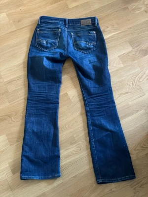Mörkblå low waist  bootcut jeans från Mavi  - Jättesnygga low waist mörkblå bootcut jeans från Mavi. Säljer pga de tyvärr blivit för små. Nypris 1000kr. Jättebra skick!🥰
