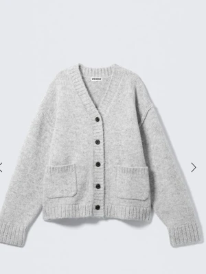 Grå kofta från Weekday - Mysig grå kofta från Weekday med v-ringning, stora framfickor och svarta knappar. Prislappen kvar då den aldrig kommit till användning 🥰🥰 storlek xs men jag skulle säga att den passar s och m också❤️ nypris 670kr❤️‍🔥❤️‍🔥