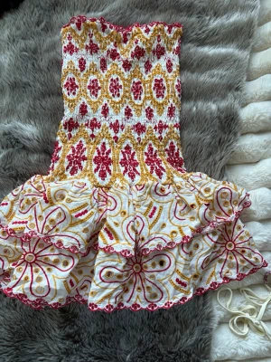 Design by amour klänning  - Jätte härlig och fin sommar klänning, men en jättefin färg. Den passar många personer eftersom att den väldigt lätt stretchas ut och dras ihop igen. Köpt för ca 800kr.  Den är i nytt skick jag har aldrig använt. Rosa/gul 