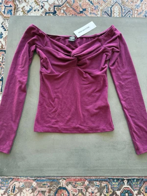 Cool topp från Urban Outfitters - Trendig, cool topp från Urban Outfitters med omlottdetalj framtill. Fin och cool tröja i ett mjukt och skönt material. Aldrig använd och har prislappen kvar.😊💕