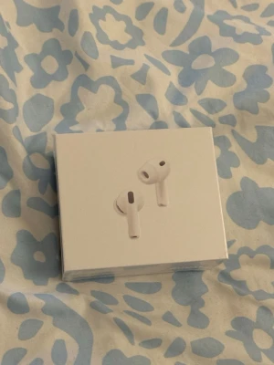 Apple AirPods Pro 3 med laddningsetui - Apple AirPods Pro 3 i vitt med trådlös laddningsetui. Snygg och stilren design med korta stjälkar och silikonproppar för bättre passform. Kompatibla med MagSafe och USB-C. Perfekta för musik, samtal och brusreducering.
