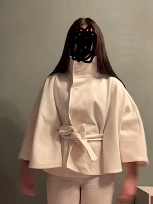 Vit cape-kappa med knytskärp - Stilren vit cape-kappa med hög krage och knappar framtill. Kappan har vida trekvartsärmar och ett matchande knytskärp i midjan för en snygg siluett. Perfekt för dig som gillar minimalistisk och modern stil.