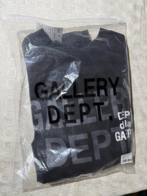 Svart Gallery Dept. t-shirt - Cool svart t-shirt från Gallery Dept. med stor tryckt logga i vitt och grått på framsidan. Klassisk rund hals och korta ärmar. Oanvänd bara testad, alla saker jag säljer blir tagen hand om innan skickad så du får så bra resultat som möjligt