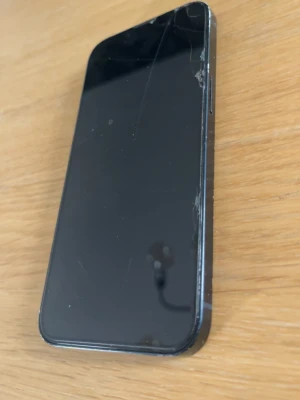 IPhone 13 - Säljer en svart iPhone med stilren design och dubbla kameror på baksidan. Telefonen har en platt framsida och bakstycke i glas samt metallram. Perfekt för dig som gillar Apples klassiska look och vill ha en mobil med bra kamera.