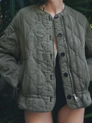 Olivgrön jacka från Zara - Säljer en olivgrön quiltad jacka med rund halsringning och både dragkedja och knappar framtill. Från Zara och köpt för ca ett år sedan, använd en vår!💞