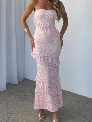 Ljusrosa spetsklänning  - Maxi klänning , axelbandslös i ljusrosa spets med volanger. Litet hål i spetsen (sista bild)