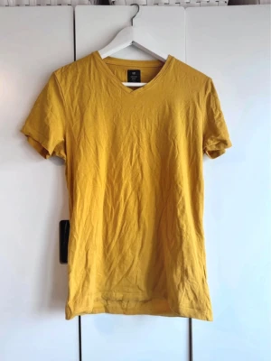 Gul v-ringad t-shirt från H&M - V-ringad t-shirt. Senapsgul. Storlek S. Från Lager 157. Använd men fint skick. 