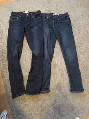 Mörkblå Levi's jeans, raka & slim - Två par klassiska Levi's jeans i mörkblå denim. Båda paren är slim taper och det är size 16a,14a passar för killar i åldern 12-14 Båda har fem fickor, kontrastsömmar och läderpatch bak i midjan. Perfekta basjeans med tidlös look och snygga detaljer.väldigt fint skick.400kr styck ny pris ligger på 1000kr