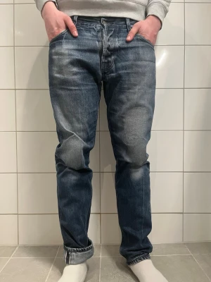 Nudie Selvedge Steady Eddie med feta slitningar  - Säljer dessa feta selvedge jeans från Nudie 🙌Jeansen är W33 L34 och modellen är Steady Eddie.  Jeansen har riktigt snygga slitningar och lagningar som ger de en unik look 🤩Finns ett minimalt hål (se bild 7) som man inte ens ser igenom, annars är jeansen i top skick! Skriv vid minsta fråga eller fundering,  priset är inte hugget i sten!