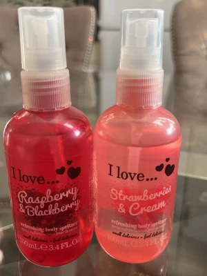 I Love... Body Spritzers Bärdoft - Två fräscha body spritzers från I Love... i dofterna Raspberry & Blackberry samt Strawberries & Cream. Flaskorna är genomskinliga med rosa och röd ton, har spraymunstycke och rymmer 100 ml vardera. Perfekt för dig som gillar söta och bäriga dofter.