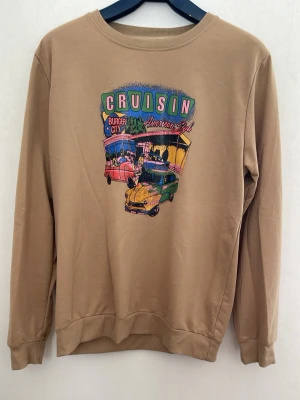 Beige sweatshirt med retrotryck - Cool beige tunn sweatshirt. Perfekt för dig som gillar vintagevibbar och streetwear. Storlek XL men jag skulle säga det är L. Lite mindre storlek. 