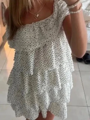 Populär vit prickig volangklänning från Zara - Supersöt vit kortklänning med svarta prickar och flera lager volanger. Offshoulder-modell med bred volang upptill som ger en romantisk vibe. Säljs inte längre och är som ny!❤️