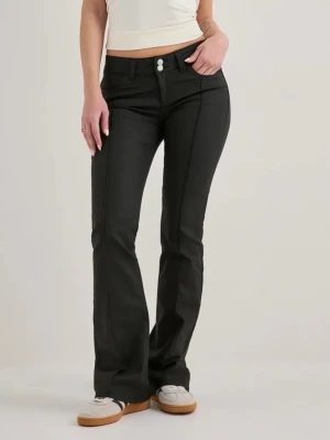 Svarta bootcut jeans med pressveck - Snygga svarta bootcut jeans med markerade pressveck framtill och dubbla knappar i midjan. Jeansen har klassisk femficksdesign och är tillverkade i ett stretchigt material för skön passform. Perfekta för en trendig och avslappnad look. ”Skinnbyxor” från Nelly, jeansen är i storlek 38 men passar mig som brukar ha 34-36💕 skriv vid frågor